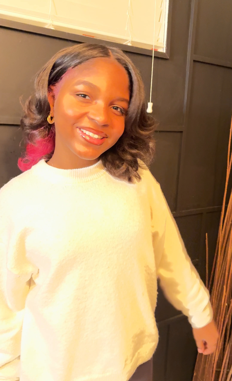 Asherah Anu smiling in a cream sweater